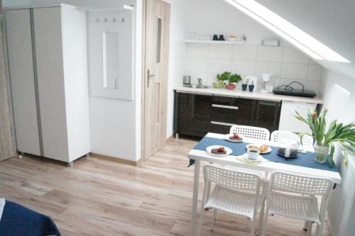 a kitchen and dining room with a table and chairs at Willa Wena in Ustka