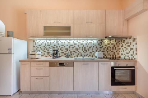 a kitchen with wooden cabinets and a white refrigerator at Katerina's Cozy Mountain View Apartment in Argostoli