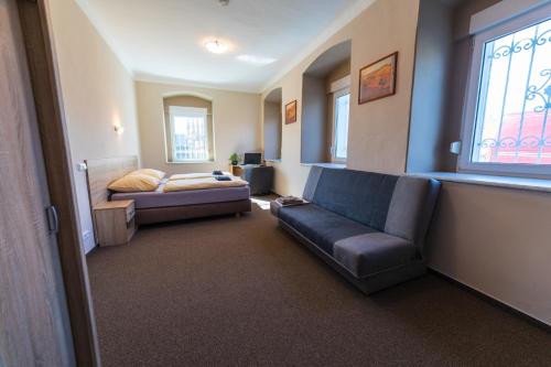 a living room with a couch and a bed at Holiday Centrum in Žatec