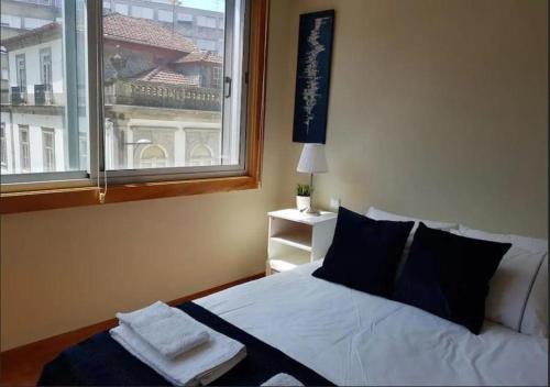 a bedroom with a white bed with a window at Cosy Santa Catarina Flat in Porto