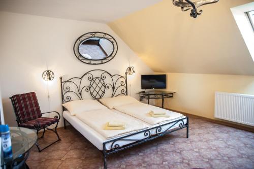 ein Schlafzimmer mit einem Bett, einem Stuhl und einem Spiegel in der Unterkunft Penzion Eden in Znojmo