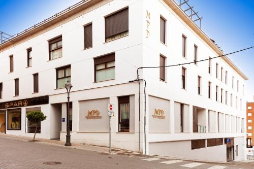 um edifício branco na esquina de uma rua em Hotel Apartamentos MPD em Mérida