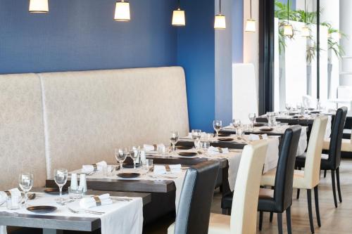 a dining room with tables and chairs with wine glasses at Atlanthal in Anglet