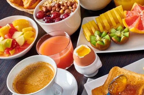 a table with plates of breakfast foods and cups of coffee at Atlanthal in Anglet