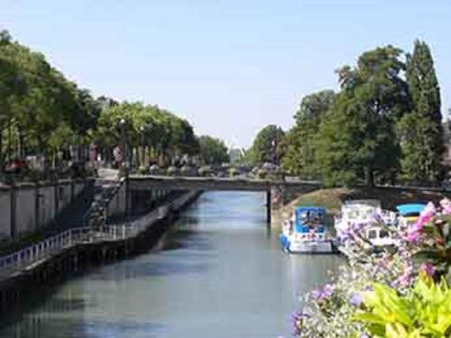 two boats in a river with a bridge at Ibis Budget Mulhouse Centre Gare in Mulhouse
