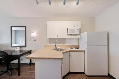 a kitchen with white cabinets and a white refrigerator at Extended Stay America Select Suites - Charlotte - Tyvola Rd in Charlotte