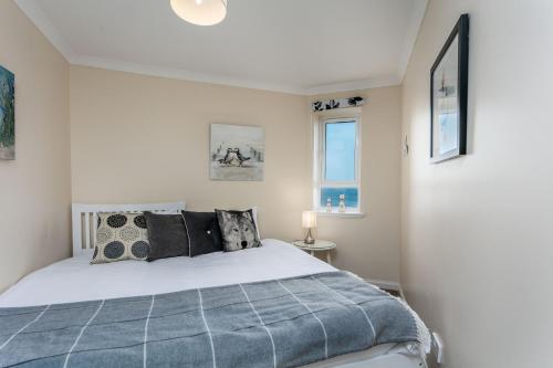 a bedroom with a bed and two windows at Arran View - Donnini Apartments in Ayr