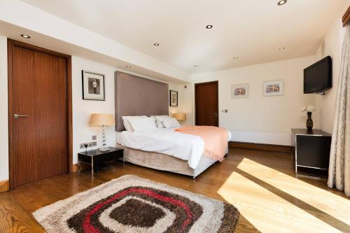 een slaapkamer met een bed en een flatscreen-tv bij Modern Elegance, steps from the Aviva! Home Cinema in Dublin