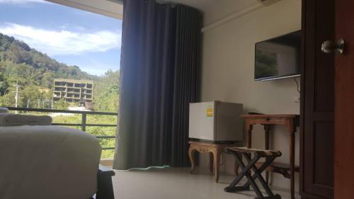 a room with a window with a refrigerator and a balcony at Chatchada House in Ao Nang Beach