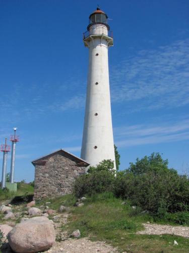 a lighthouse sitting on top of a hill at Kihnu Sadama Öömaja Guesthouse in Lemsi