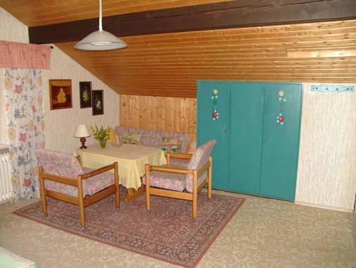 Zimmer mit einem Tisch, Stühlen und einem Tisch in der Unterkunft Ferienwohnung Uhrmann Franz in Lindberg