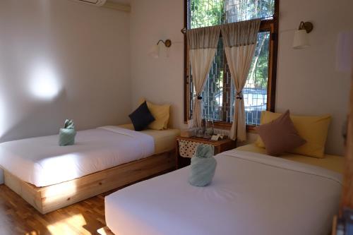 a room with two beds and a window at Paiyannoi Guesthome in Chiang Mai