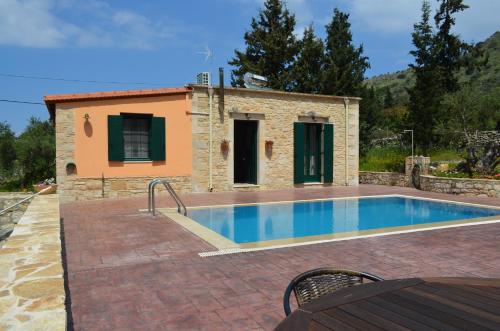 a villa with a swimming pool in front of a house at La Villa "Casa di Lydia" in Gavalochori