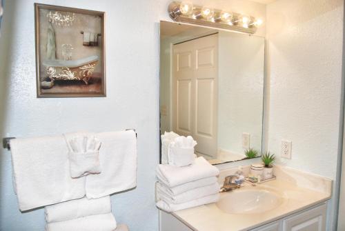 bagno con lavandino, specchio e asciugamani di Grand Atlantic Resort 601 Eff Condo a Myrtle Beach