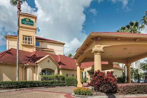 a hotel with a sign on top of a building at La Quinta by Wyndham Orlando Airport - On Property Food Trucks & Free Airport Shuttle! in Orlando