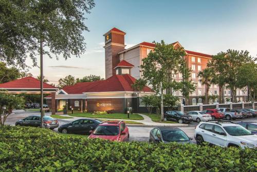 un parcheggio con auto parcheggiate di fronte a un edificio di La Quinta by Wyndham Orlando UCF a Orlando