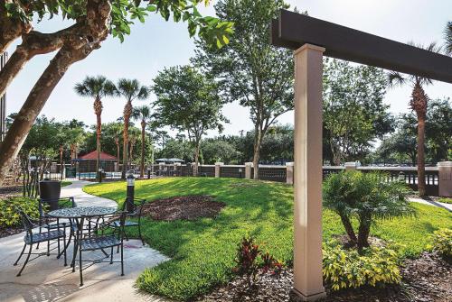 a patio with a table and chairs in a park at La Quinta by Wyndham Orlando UCF in Orlando