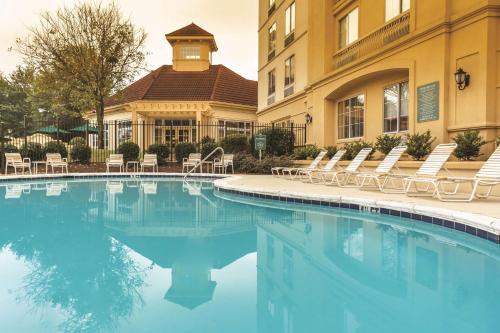 a hotel swimming pool with chairs and a building at La Quinta by Wyndham Atlanta Ballpark/Galleria in Atlanta