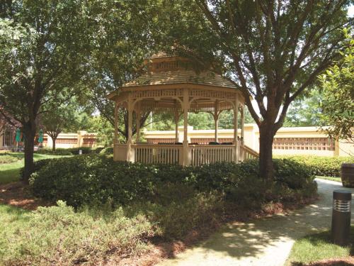 a wooden gazebo in a park with trees at La Quinta by Wyndham Raleigh/Durham Southpoint in Durham