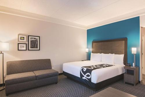 a hotel room with a bed and a couch at La Quinta by Wyndham Orlando UCF in Orlando