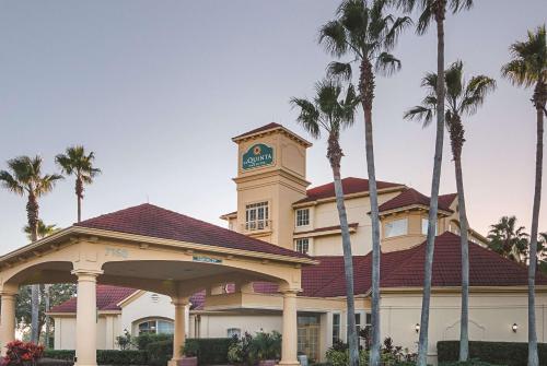 a hotel with a clock tower on top of a building at La Quinta by Wyndham Orlando Airport - On Property Food Trucks & Free Airport Shuttle! in Orlando