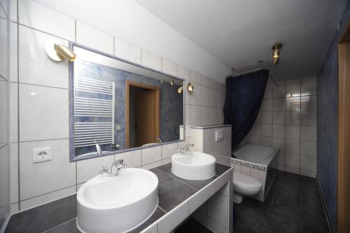 a bathroom with two sinks and a toilet at Altes Zollhaus Nähe Mullerthal Luxemburg in Ammeldingen