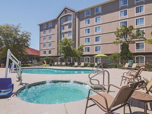 una piscina en un hotel con sillas y un edificio en La Quinta by Wyndham Oklahoma City - NW Expwy en Oklahoma City