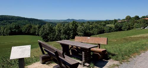 a picnic table and bench on the side of a field at Bergoase Hütte und Hostel Sauna Kamin Lagerfeuer in Mittelndorf