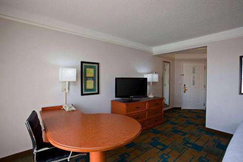 a living room with a table and a television at La Quinta by Wyndham Winston-Salem in Winston-Salem