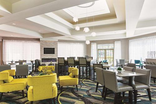 a dining room with yellow chairs and tables at La Quinta by Wyndham Orlando UCF in Orlando