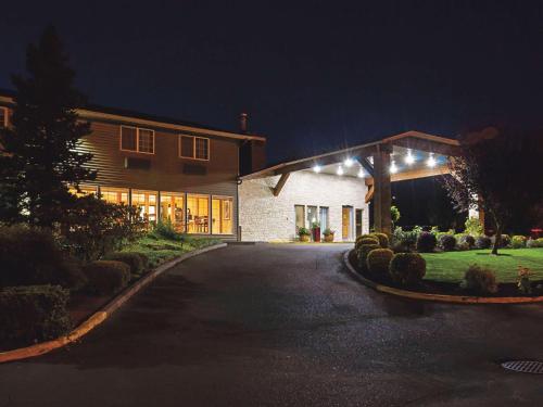 a house with lights on the side of a driveway at La Quinta by Wyndham Woodburn in Woodburn