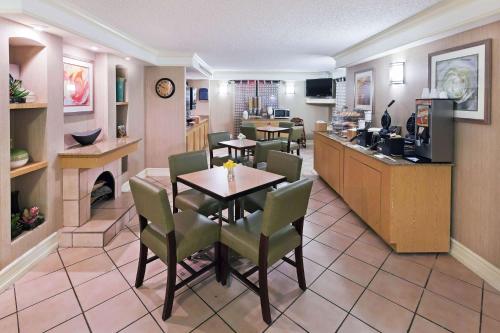 a restaurant with a table and chairs and a bar at La Quinta Inn by Wyndham Amarillo Mid-City in Amarillo