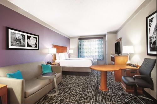 a hotel room with a bed and a desk at La Quinta Inn & Suites by Wyndham Jackson Airport - Pearl in Pearl