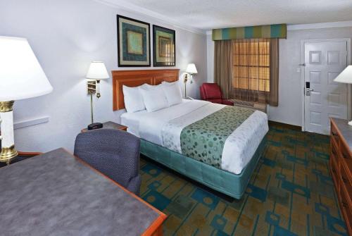 a hotel room with a bed and a table and chairs at La Quinta Inn by Wyndham Austin Oltorf in Austin