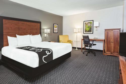 a hotel room with a large bed and a desk at La Quinta Inn & Suites by Wyndham San Antonio Riverwalk in San Antonio