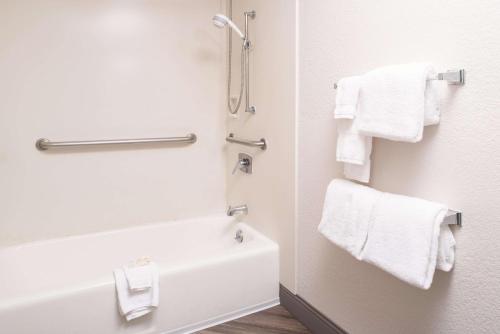 a bathroom with a bath tub and towels at La Quinta by Wyndham DFW Airport South / Irving in Irving