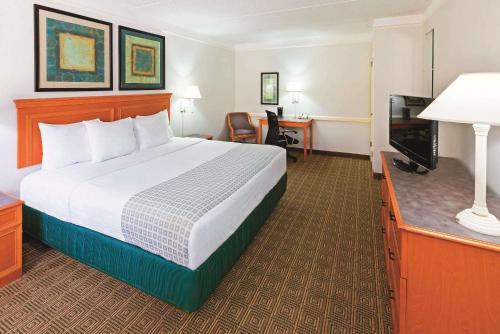 a hotel room with a bed and a flat screen tv at La Quinta Inn by Wyndham College Station in College Station
