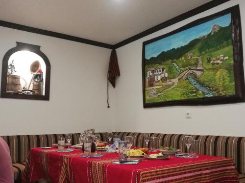 una mesa en un restaurante con un mantel rojo en Kuma Lissa Guest House, en Kozhari