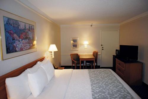 a hotel room with a bed and a desk with a television at La Quinta Inn by Wyndham Tampa Bay Pinellas Park Clearwater in Pinellas Park