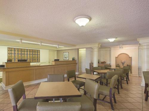 a restaurant with tables and chairs and a waiting area at La Quinta Inn by Wyndham San Diego Chula Vista in Chula Vista