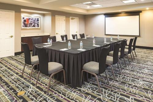 a conference room with a long table and chairs at La Quinta by Wyndham St. Louis Westport in Saint Louis