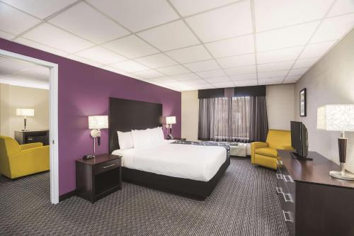 a hotel room with a bed and a tv at La Quinta Inn by Wyndham Fresno Yosemite in Fresno