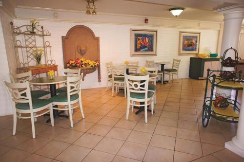 a restaurant with tables and chairs in a room at La Quinta Inn by Wyndham Bakersfield South in Bakersfield