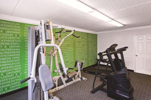 a gym with two tread machines and a green wall at La Quinta Inn by Wyndham Fresno Yosemite in Fresno