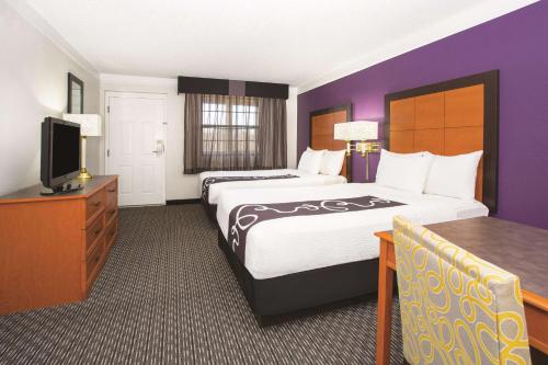 a hotel room with two beds and a television at La Quinta Inn by Wyndham Denver Westminster in Westminster