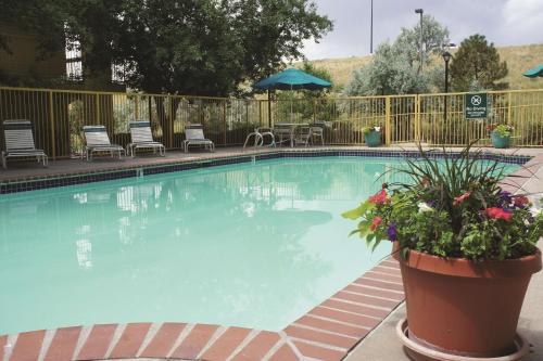 a large swimming pool with chairs and umbrellas at La Quinta Inn by Wyndham Denver Westminster in Westminster