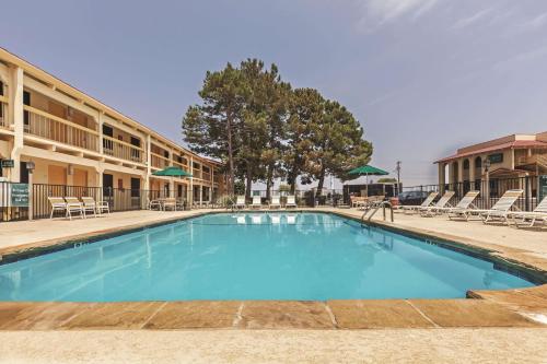 einen Pool in einem Hotel mit Stühlen in der Unterkunft La Quinta Inn by Wyndham and Conference Center San Angelo in San Angelo