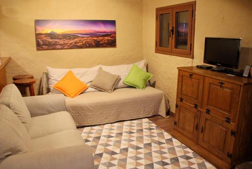 a living room with a bed and a tv at Casa Tajinastes del Teide in Las Cañadas del Teide