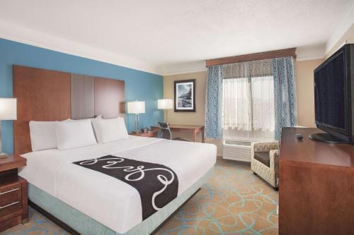 a hotel room with a bed and a flat screen tv at La Quinta by Wyndham Elizabethtown in Elizabethtown