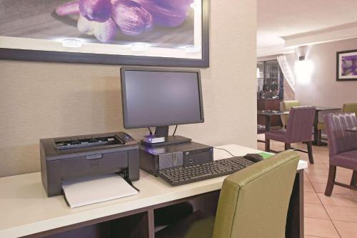 a desk with a computer and a monitor and keyboard at La Quinta Inn by Wyndham Salt Lake City Midvale in Midvale